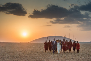 Amber and David walking on the plains with a group of Maasai warriors